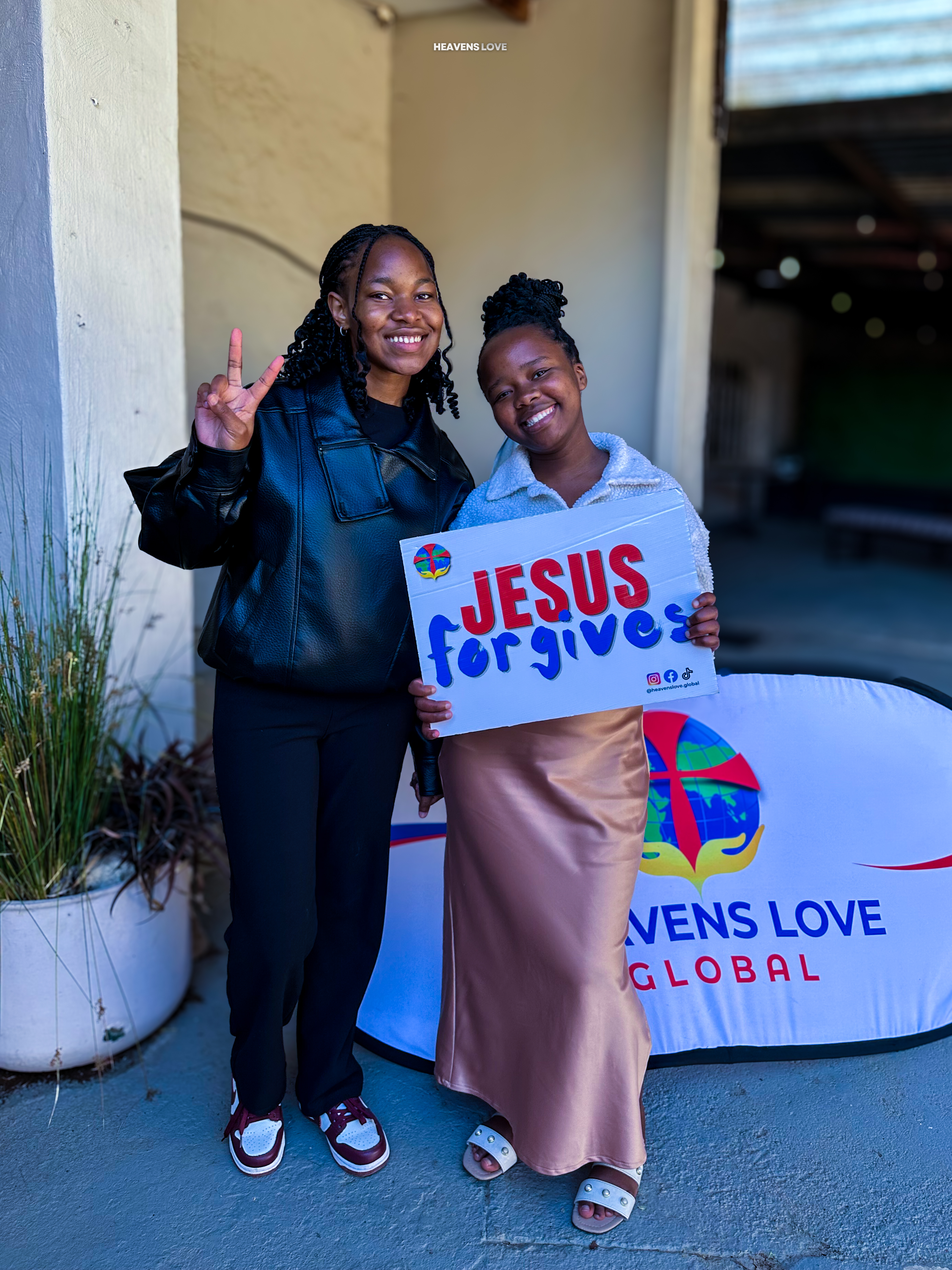 Heavens Love church member holding a sign that reads Jesus forgives
